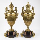 A pair of large gilded bronze decorative vases on a marble base