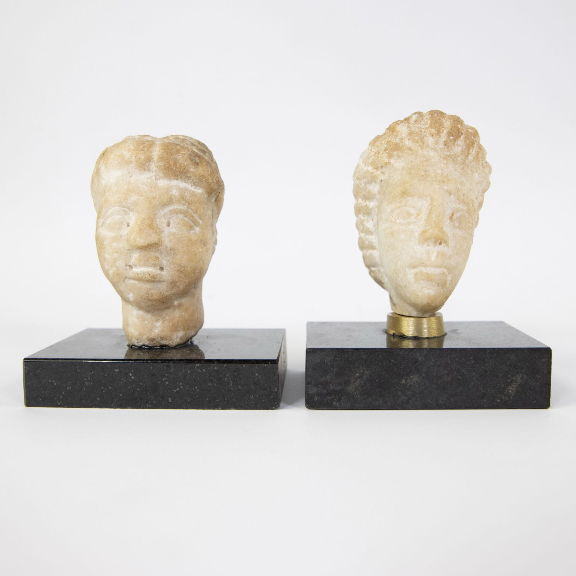 2 Roman heads in white stone on marble base
