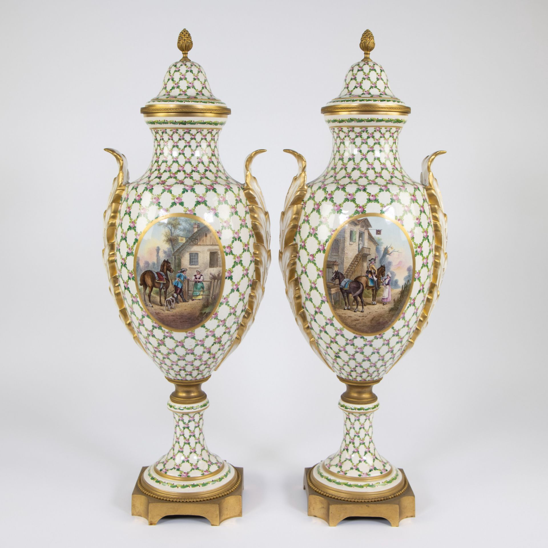 Pair of porcelain Sèvres vases on a gilt brass base with a background of leaves and pink flowers, pa