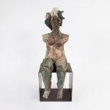 Ceramic statue of seated woman on metal pedestal, monogram VV