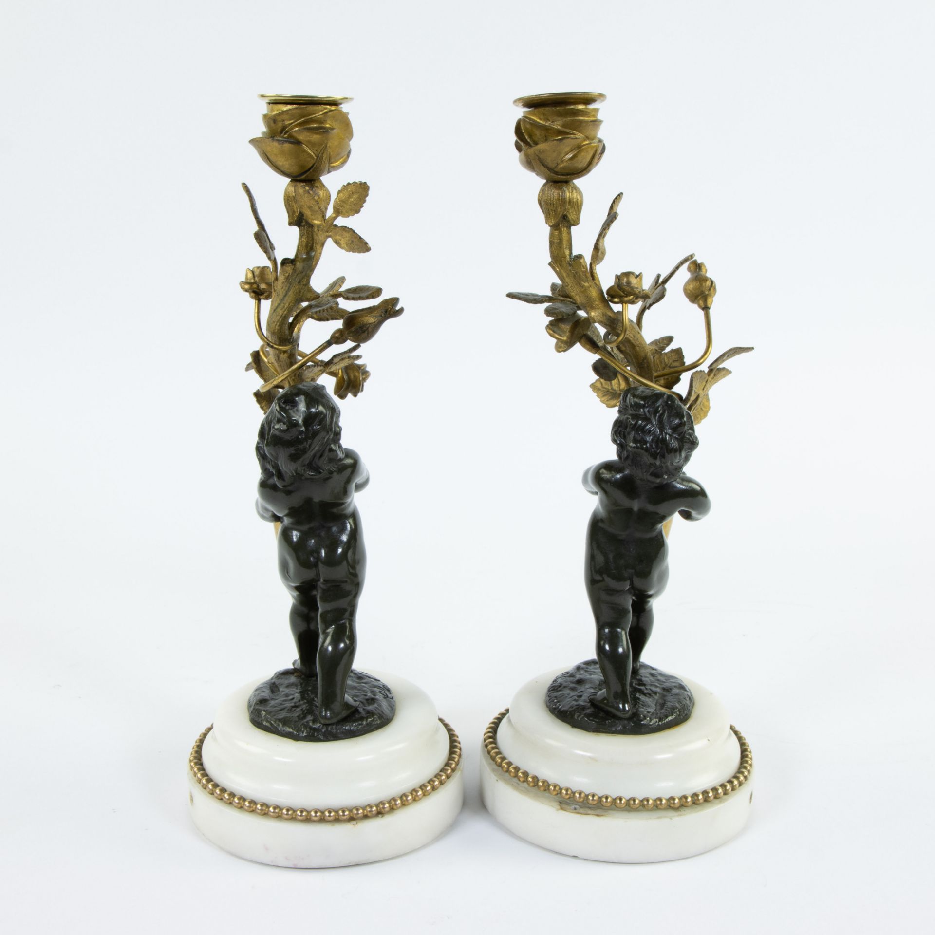 Pair of candlesticks gilded stem as light point carried by brown patinated bronze children on white - Image 4 of 5