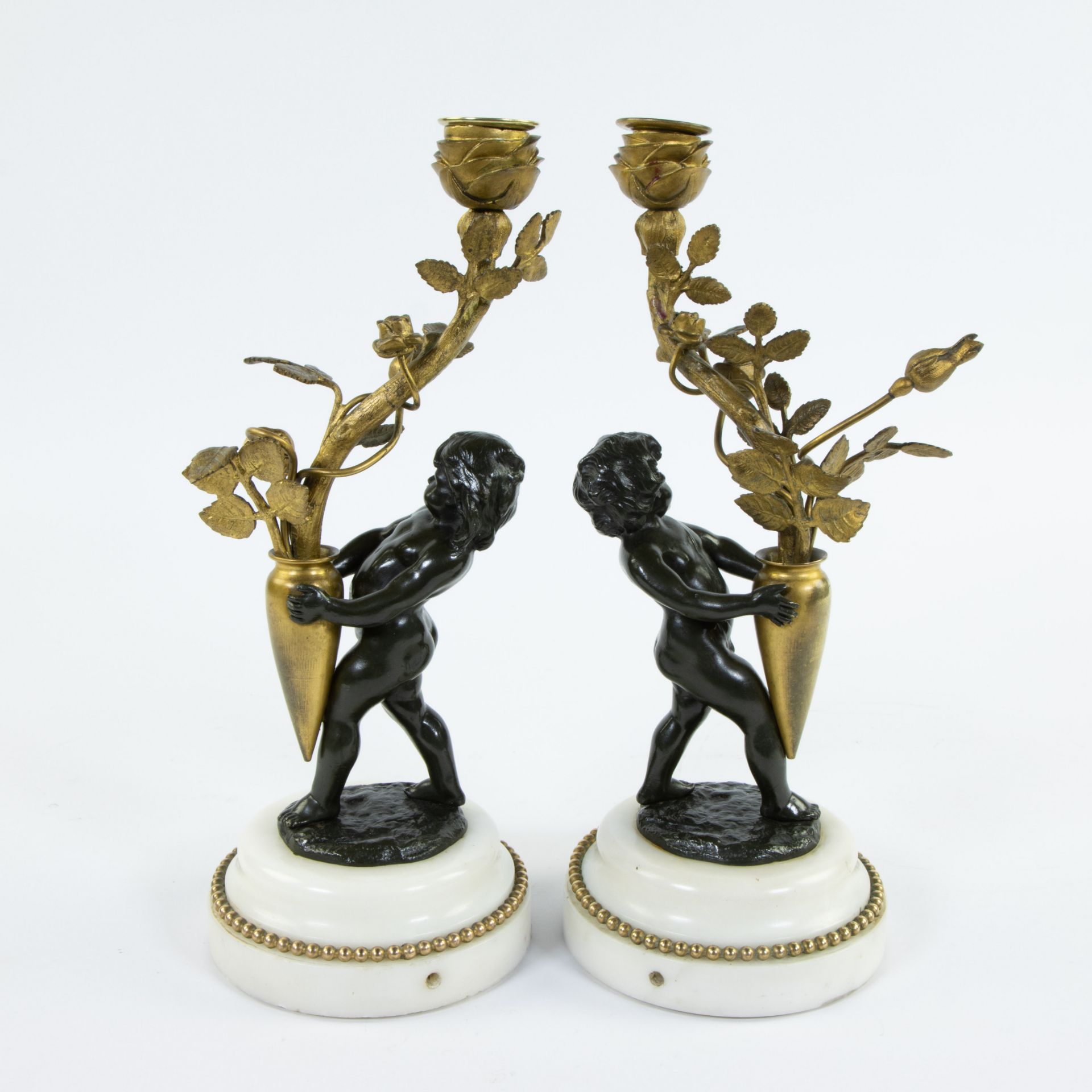 Pair of candlesticks gilded stem as light point carried by brown patinated bronze children on white - Image 3 of 5