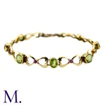 A Suffragette Bracelet The 15ct gold bracelet is set with peridot and garnet in the suffragette