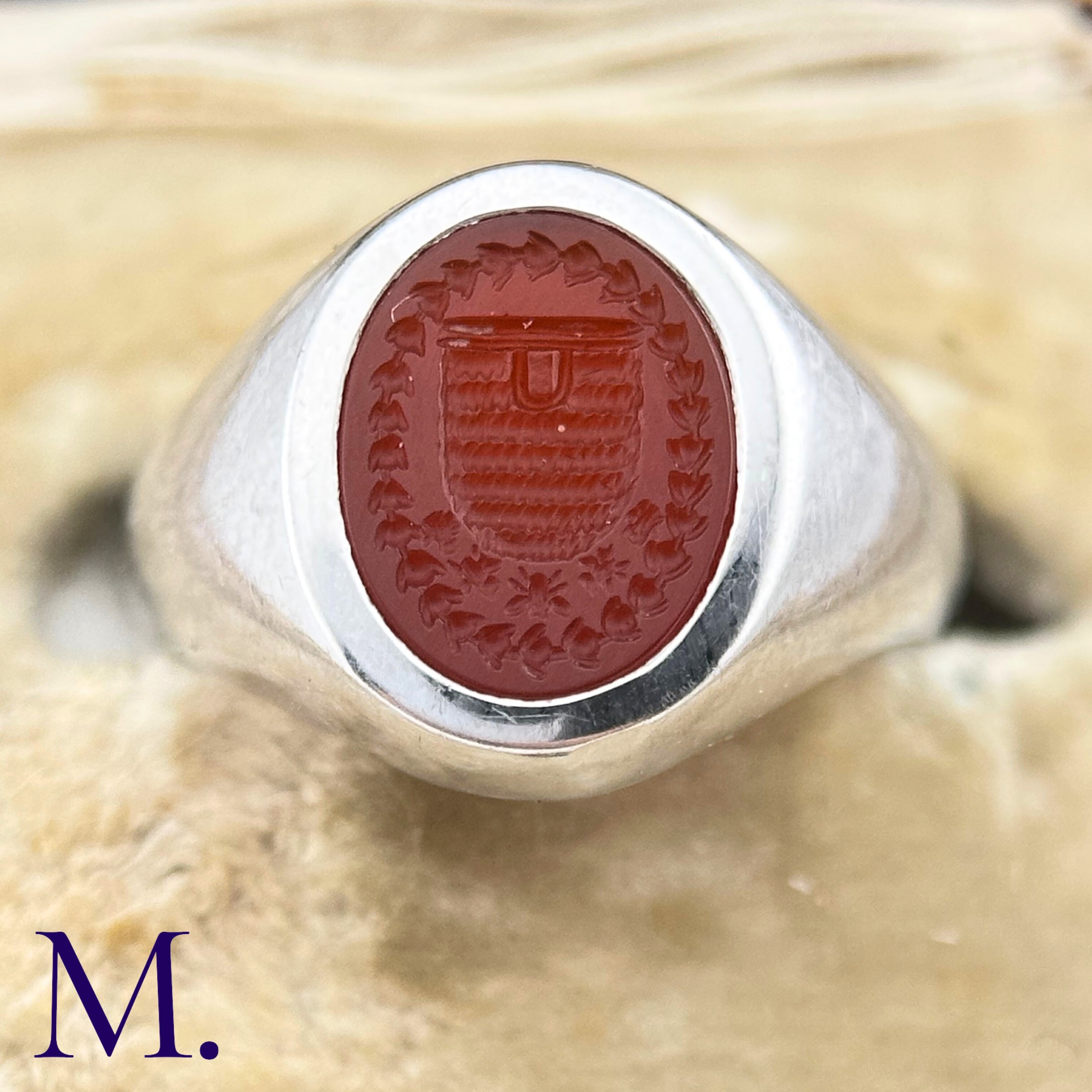 A Platinum and Carnelian Signet Ring The platinum ring is set with a carved oval-shaped carnelian