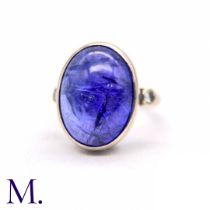 A Cabochon Tanzanite and Diamond Ring The 18ct white gold ring is set with a large cabochon
