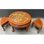 A Chinese low table with glass top and two matching footstools.