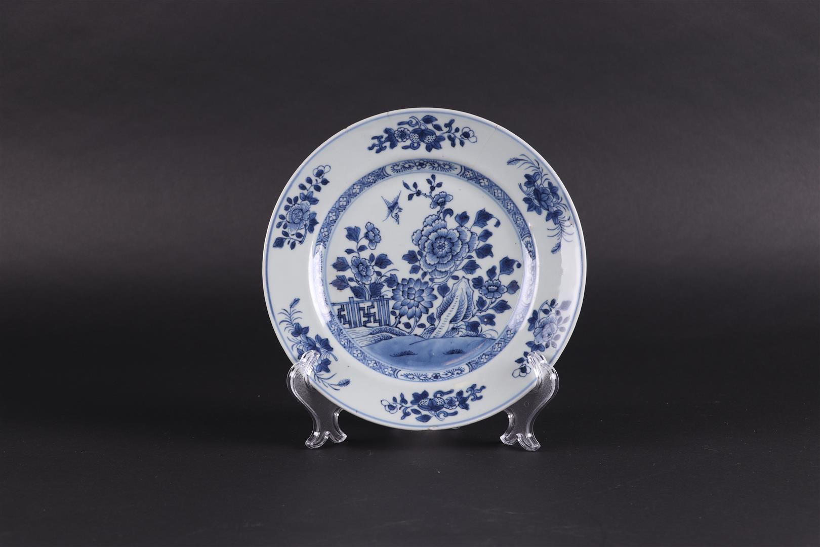 A porcelain plate with chrysanthemum and lotus on rock, with fence decor. China, Qianlong.