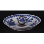 A porcelain saucer with floral decor and silver carrying handle in the center. China, Yongzheng.