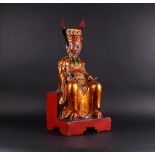 A large wooden, partly gilded, statue of an emperor. China, 20th century.