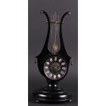 A wooden black lacquered harp mantel clock with open pendulum. France, mid 20th century.