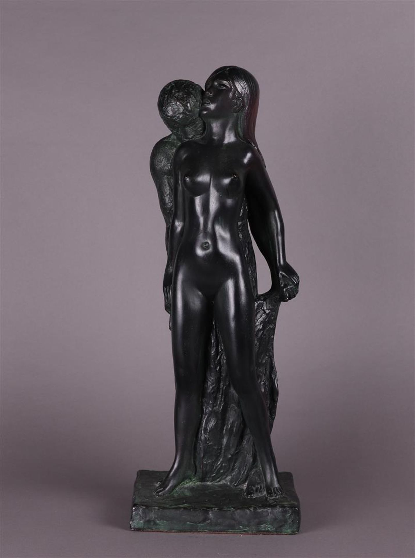A patinated plaster sculpture of a man and woman in an embrace. 
