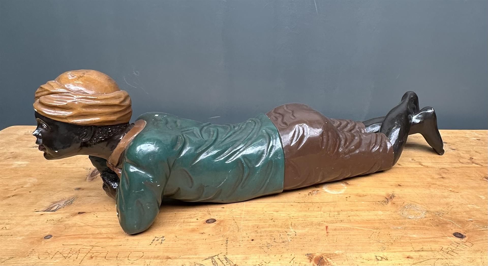 A wooden sculpture of a reclining Morian, 20th century.