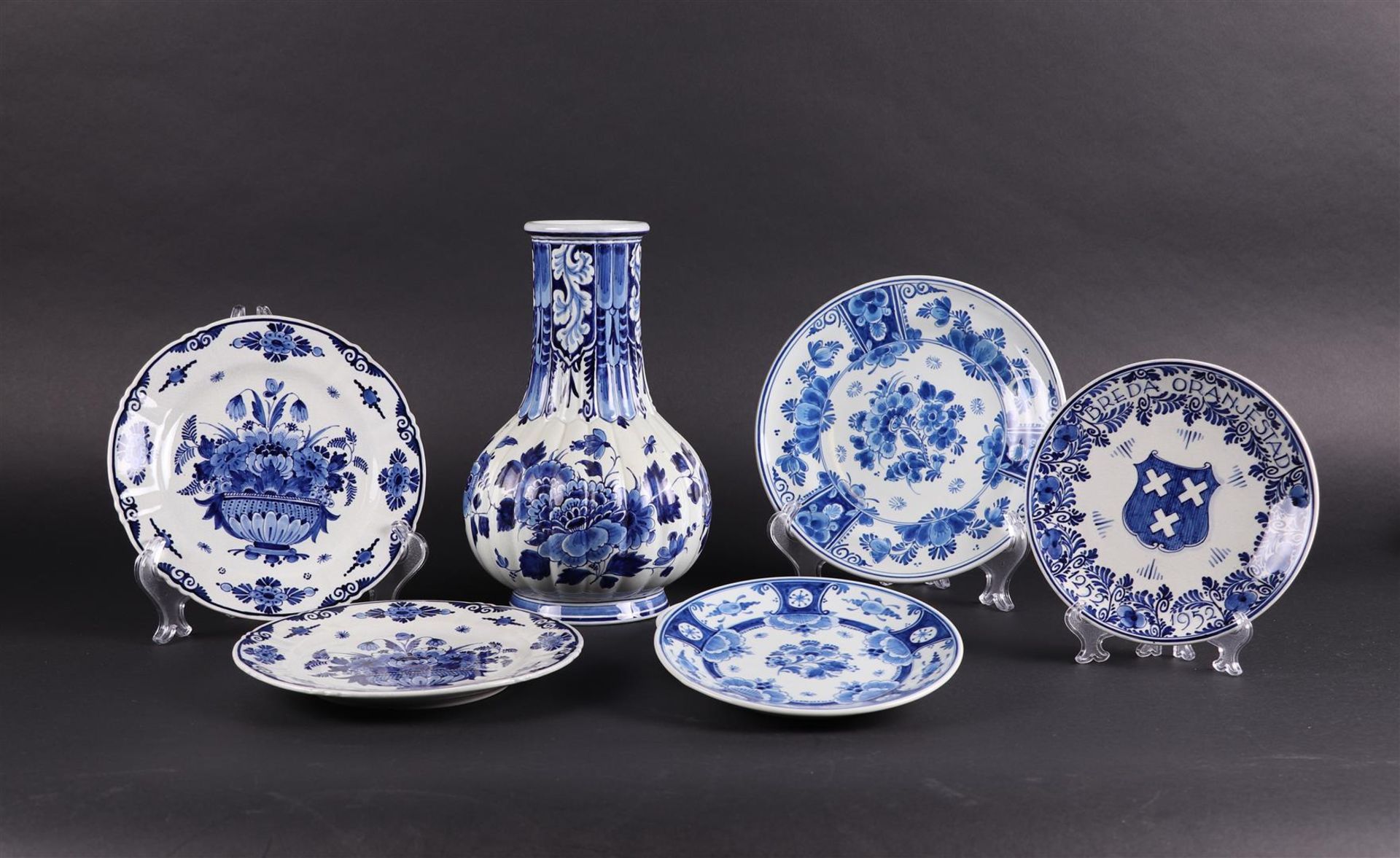 A lot consisting of Delft Blue plates and a ditto vase. All marked De Porceleyne Fles.