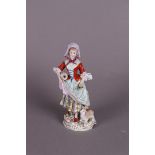 A porcelain figure of a girl carrying a jug and flowers, marked Sitzendorf Thüringen.