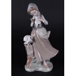 A porcelain figure of a girl with two pigeons, marked Lladro. Spain, late 20th century.