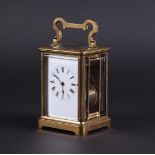 A brass travel alarm clock, dial in white enamel shows the hours in Roman numerals, strike on gong.
