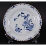 A porcelain plate with a decoration of a pine tree by the river with a crane. China, Qianlong.