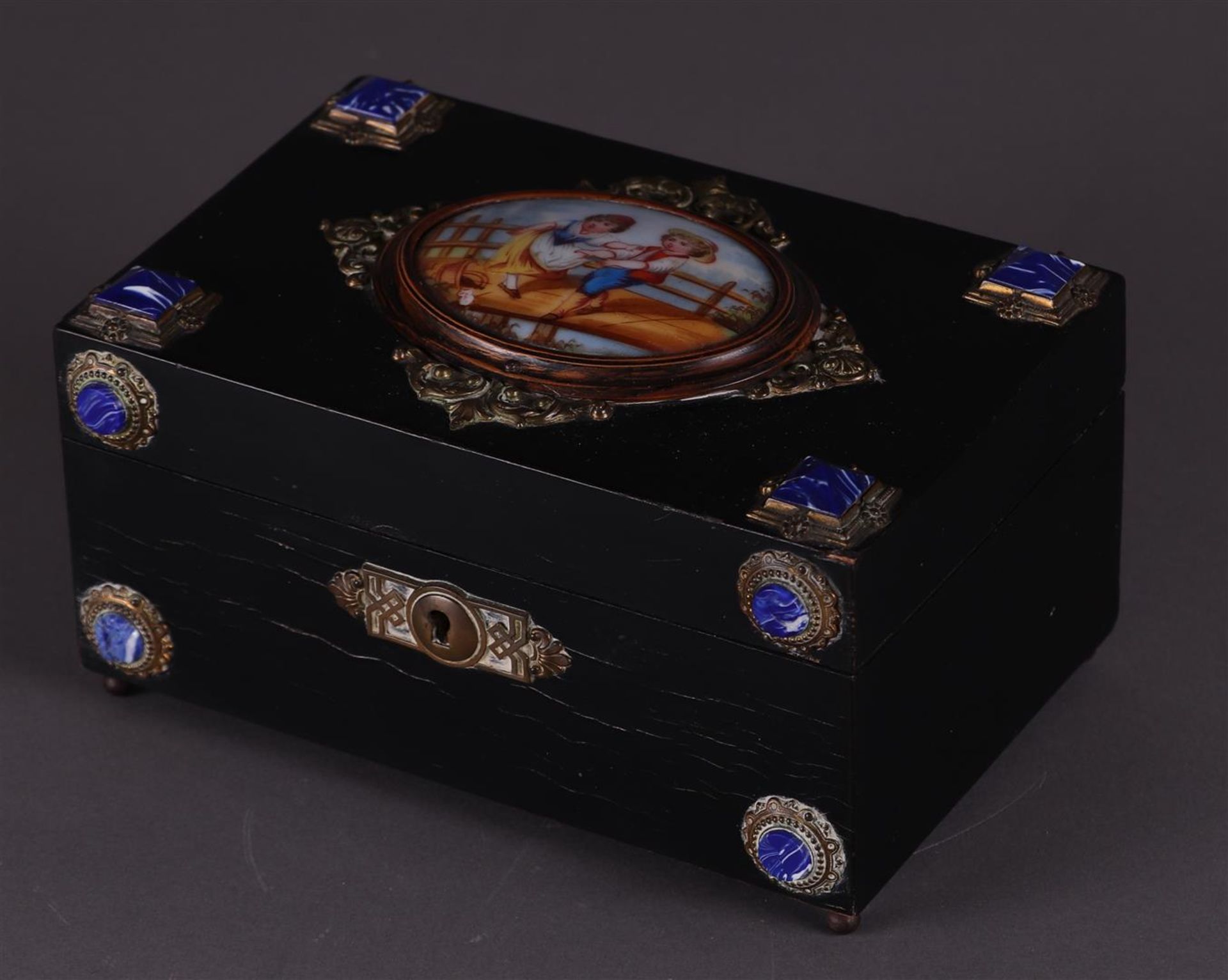 A black box with enamel plaque depicting children on a bridge. 19th century.