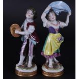A set of two porcelain figures of a boy playing music and a dancing girl, marked Volkstedt Thuringen