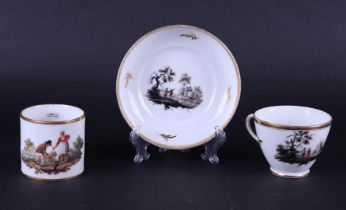 A porcelain cup and saucer with rich, grisaille, landscape decoration.