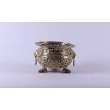 A brass cache pot on claw feet and decorated with lion heads. Holland early 19th century.