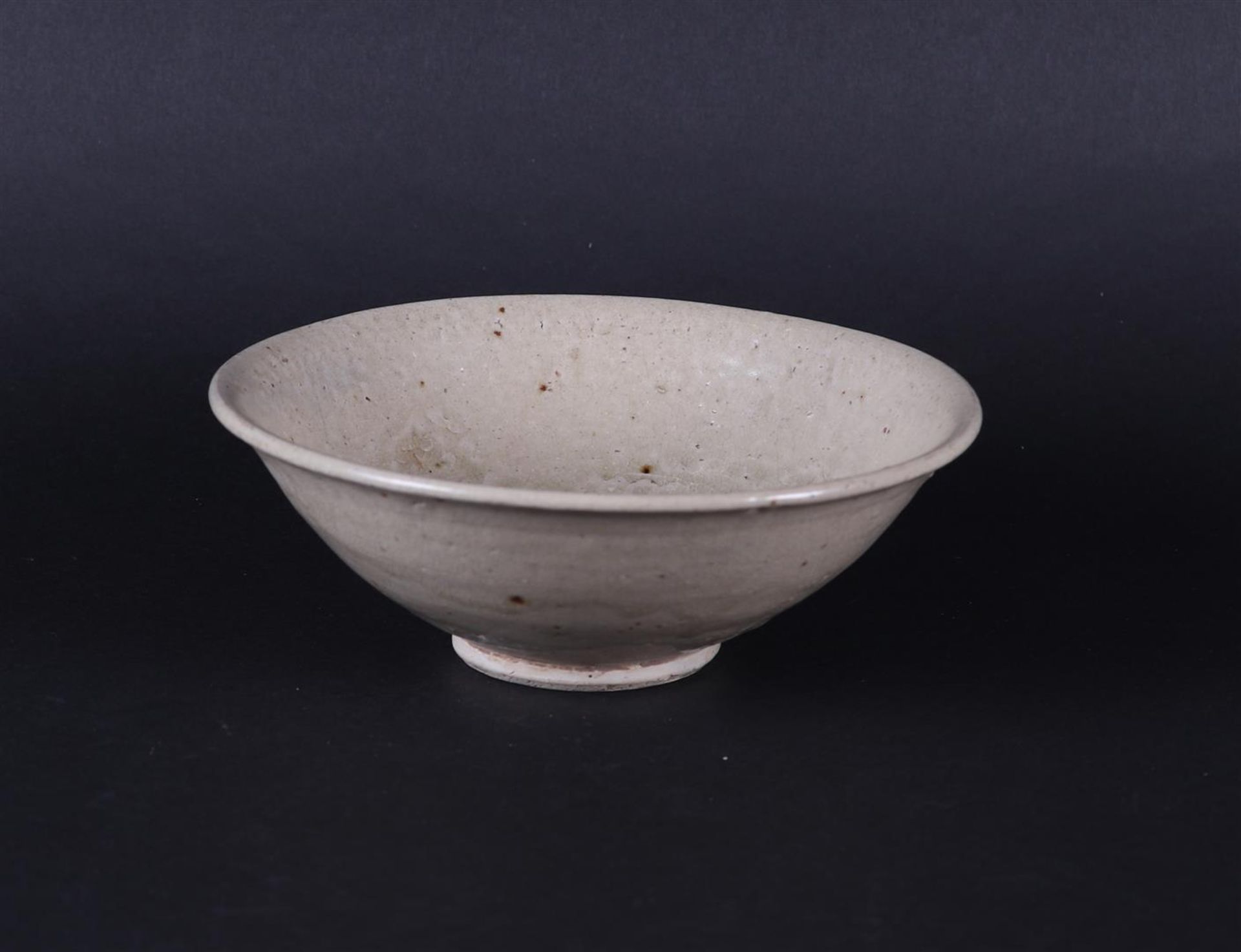 A gray Celadon bowl with ribbed center relief decoration. China, Early Ming period.