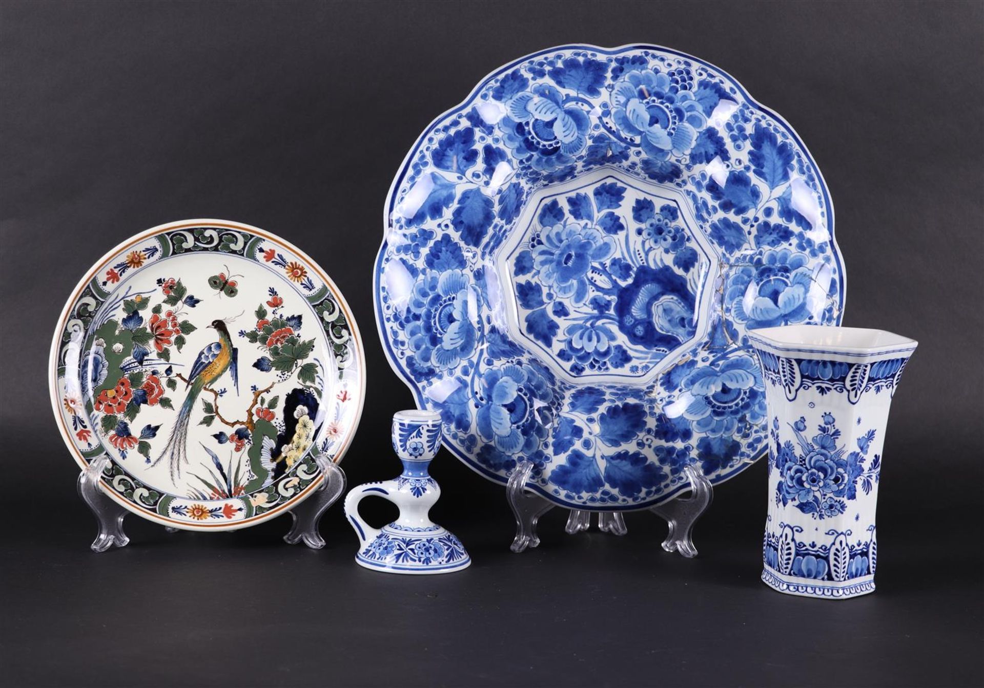 A lot of pottery consisting of a polychrome plate, a  vase, a candlestick and a folding dish. 