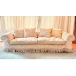 A spacious sofa upholstered in white damask and loose cushions