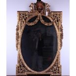 A cut oval mirror in a gilded frame with garlands and putti. 20th century.