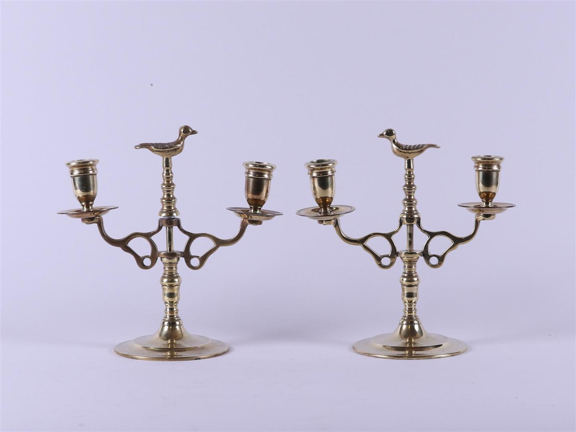 A set of brass two-light candlesticks with a bird in the centre. Holland, 19th century.