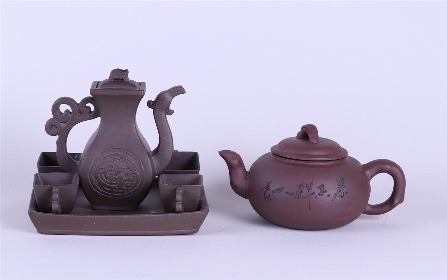 A lot consisting of a Yixing teapot, a ditto pot and four cups on a tray. China, 20th century.