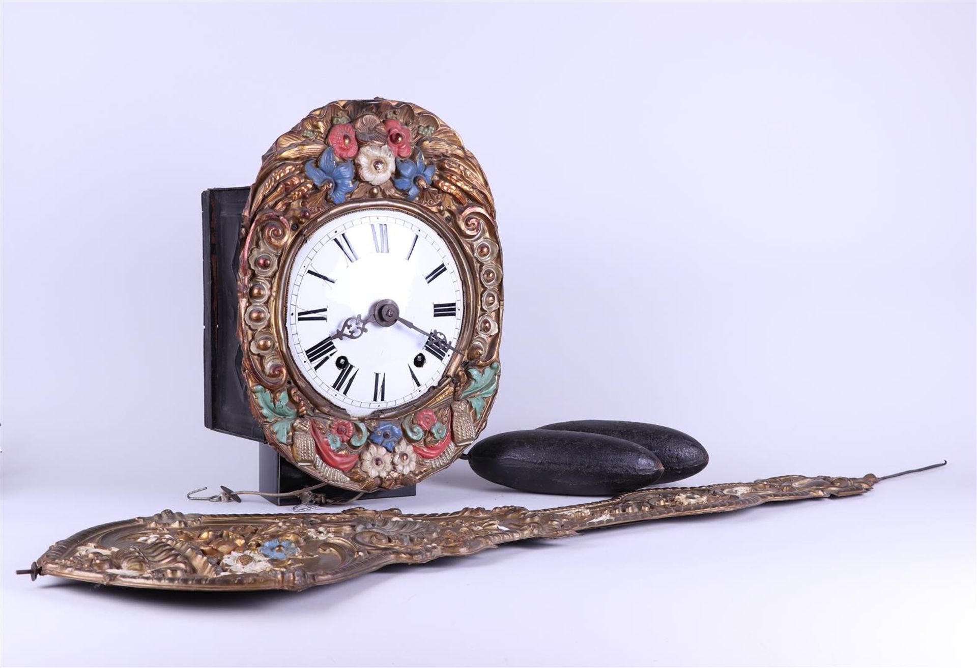 A French comptoise clock with a polychrome brass rim and flowerpendulum. 19th century.