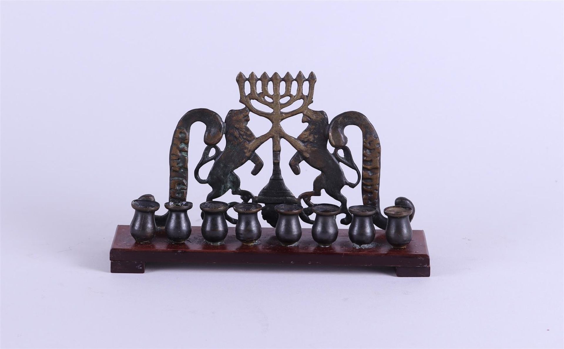 A copper Hanukkah on wooden base. 19th century.