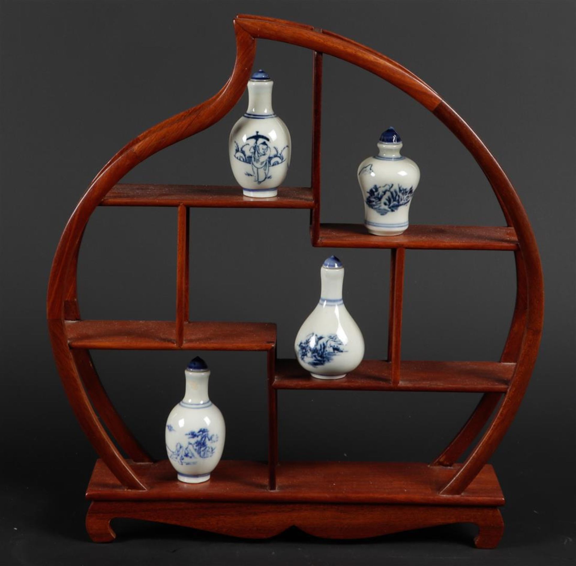 A lot of porcelain snuff bottles with various scenes, on a peach-shaped fruit wooden rack.