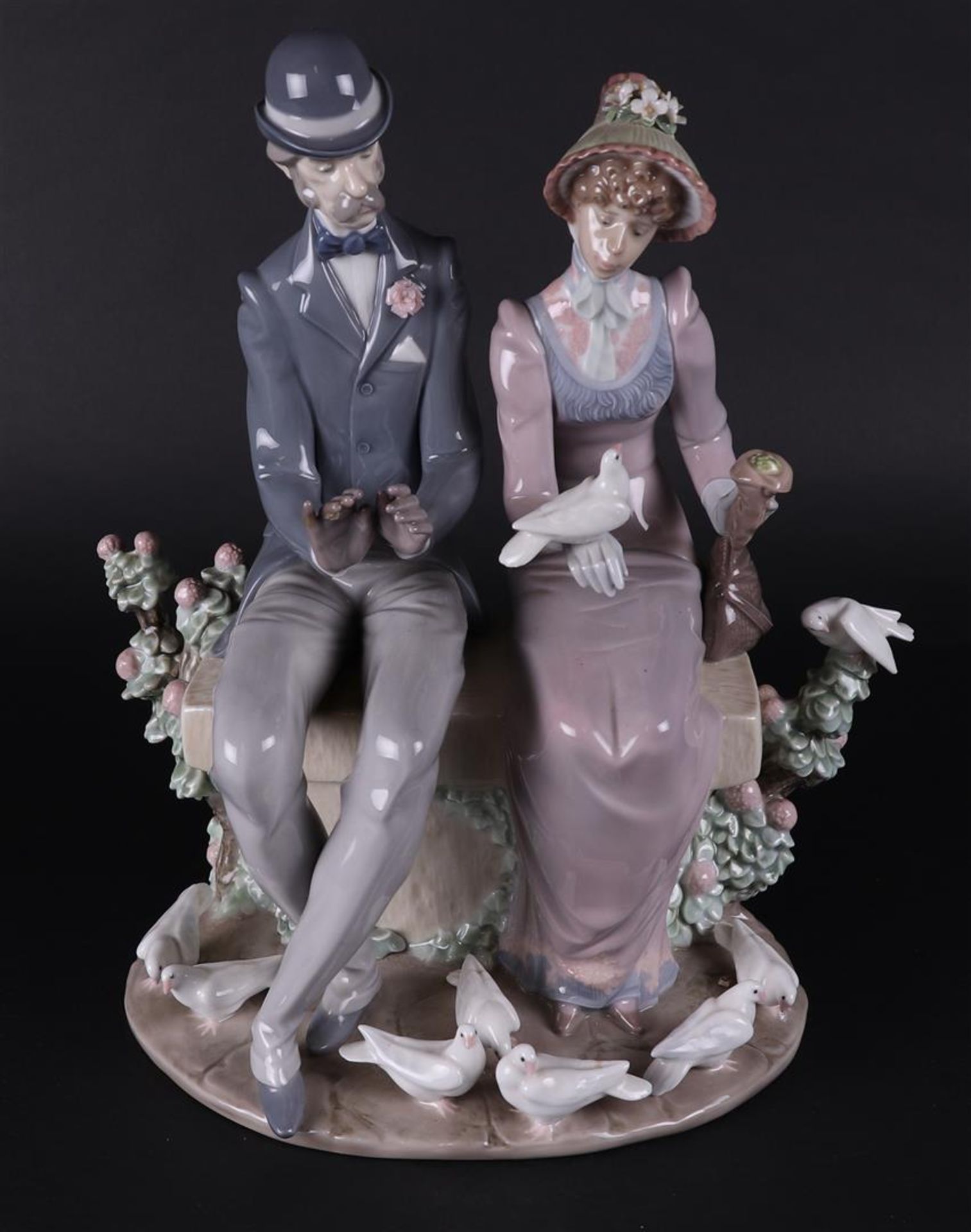 A porcelain  group of a young couple on a bench, marked Lladro. Spain, late 20th century.