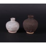 A set of stoneware storage jars. One grey, the other dark grey. China early Ming.