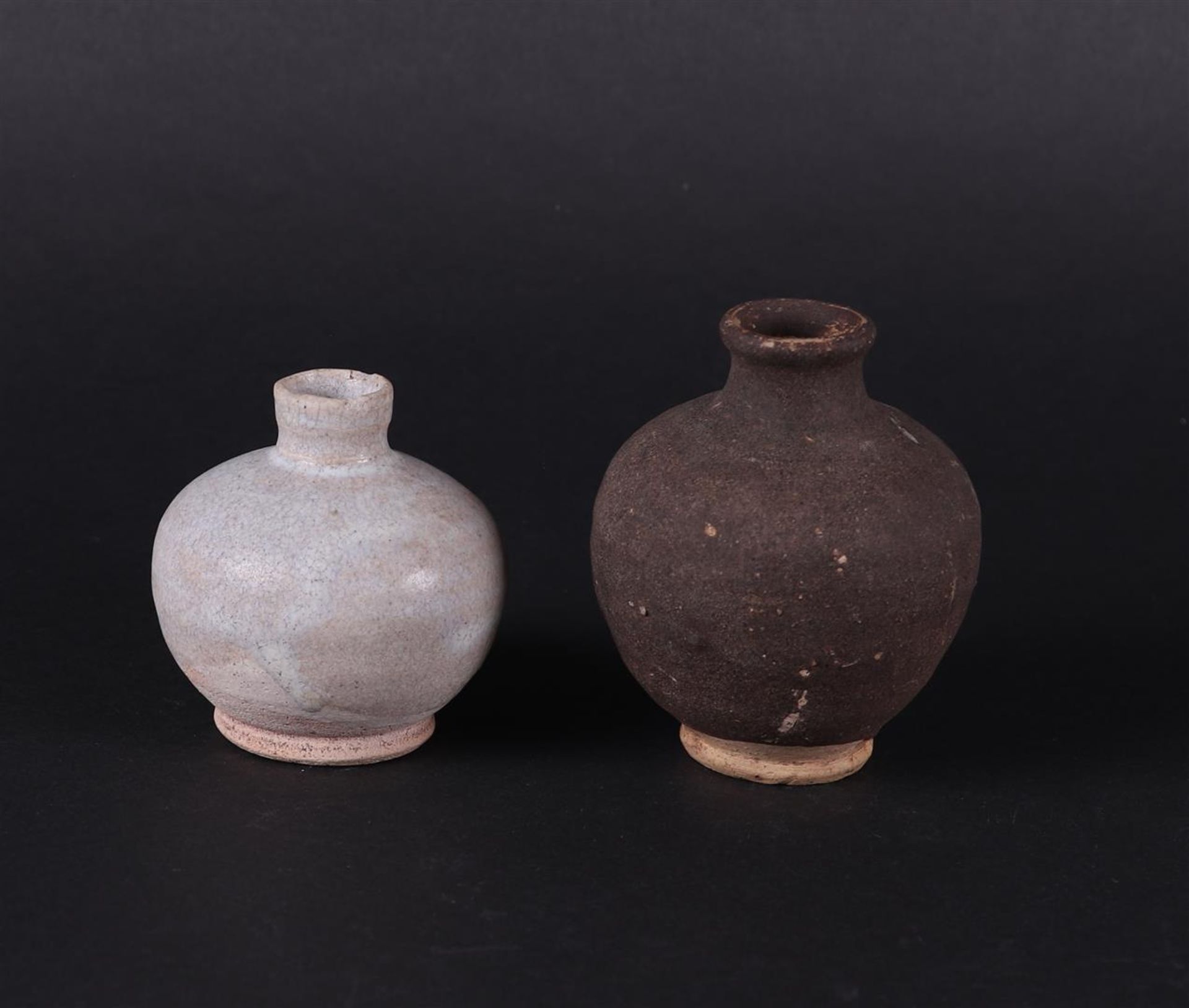 A set of stoneware storage jars. One grey, the other dark grey. China  early Ming.