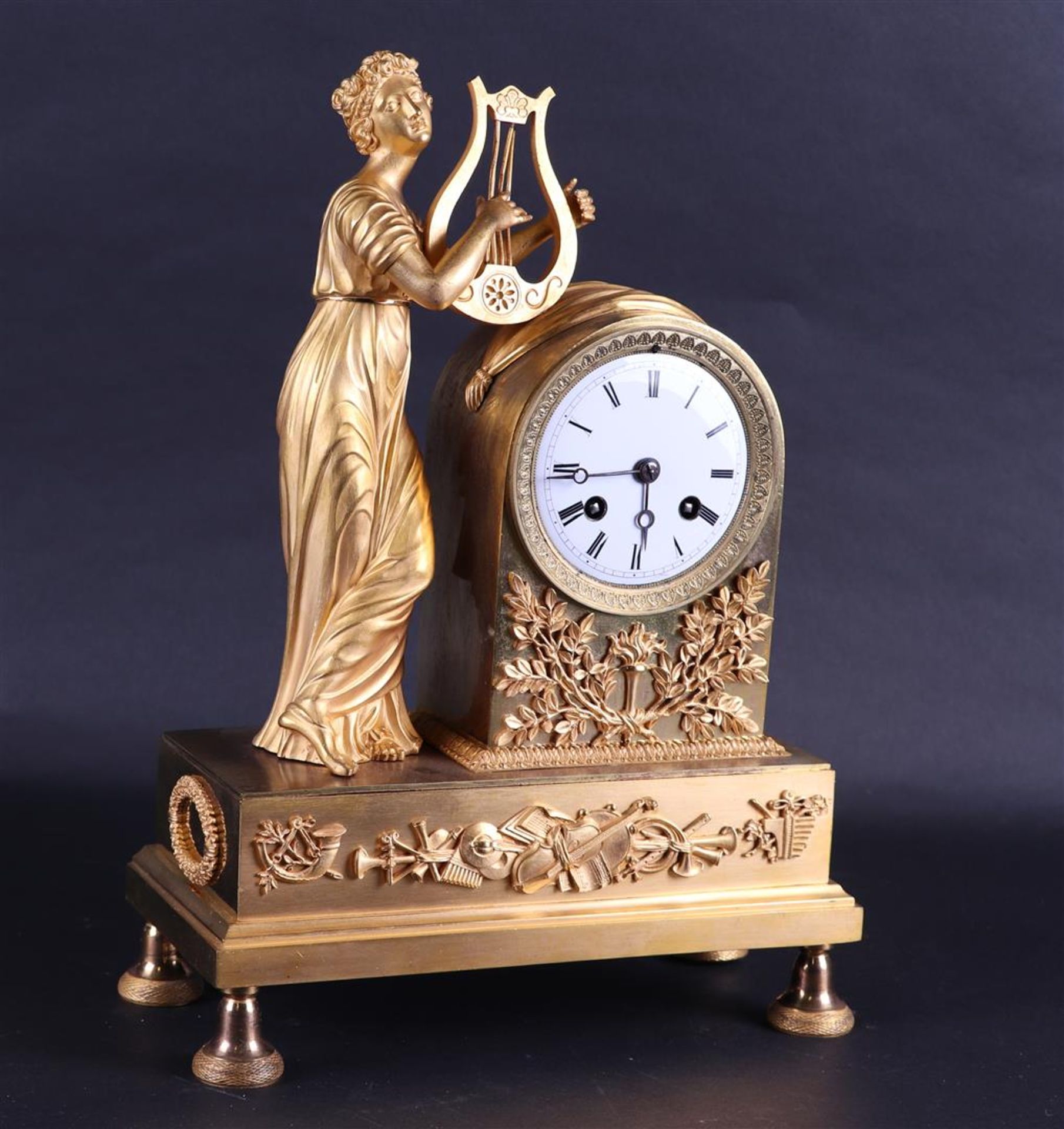 A 19th century fire-gilt mantel clock with harp-playing muse.