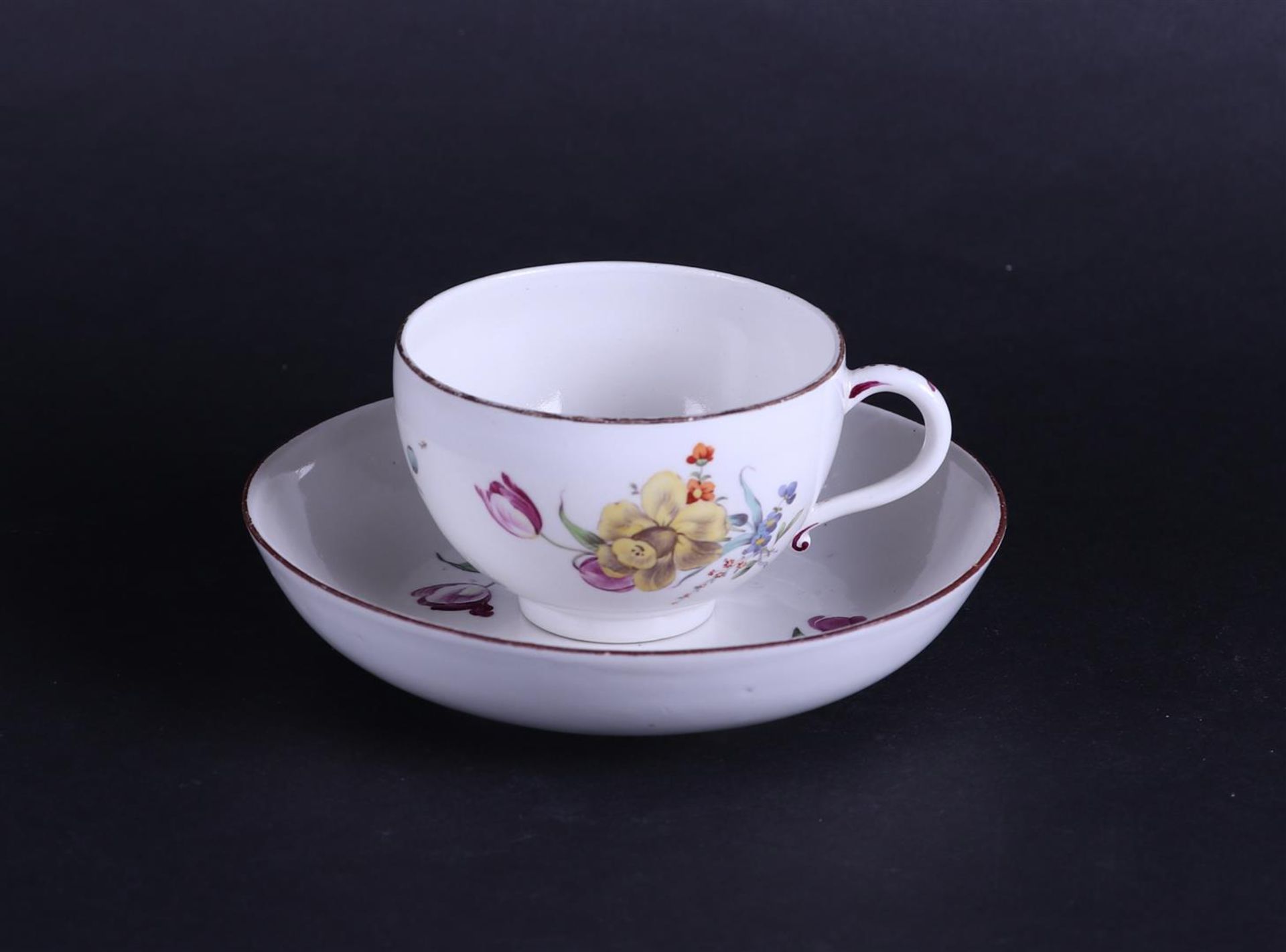 A porcelain cup and saucer with rich, polychrome floral decoration. German, Höchst 18th century.