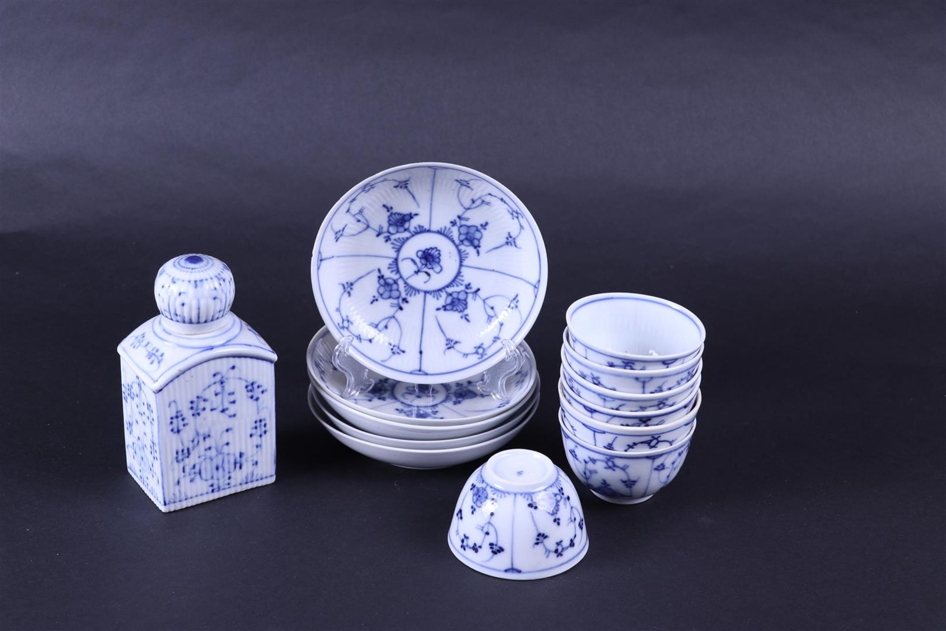 A lot consisting of (5) Zwiebelmuster plates, (6) cups  and a tea caddy, 19th century.