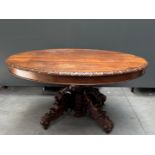 An antique coulisen table / hunting table with carved fruits on the legs.