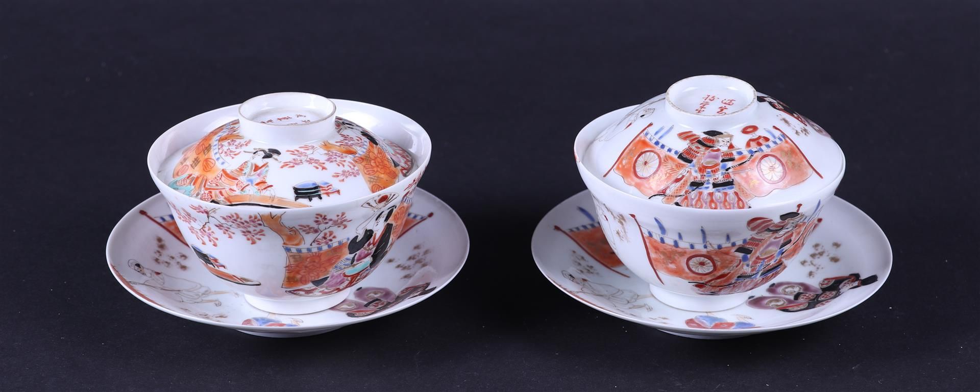 A set of two porcelain polychrome lidded cups and saucers decorated with various figures, marked. 