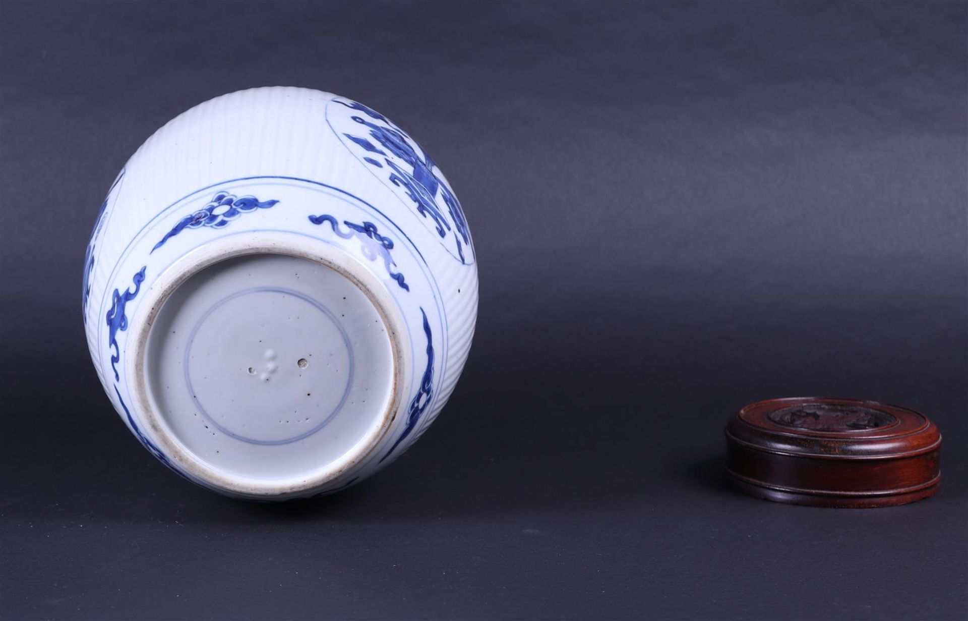 A large ribbed porcelain ginger jar decorated with various antiques and a wooden lid. China, Kanxi. - Image 7 of 7