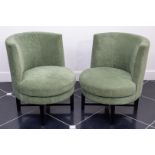 A set of two modern cocktail chairs covered with green fabric.