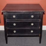 A blackened wooden chest of drawers.