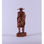 A Madegascar carving depicting a walking man with hat and stick, 20th century. .