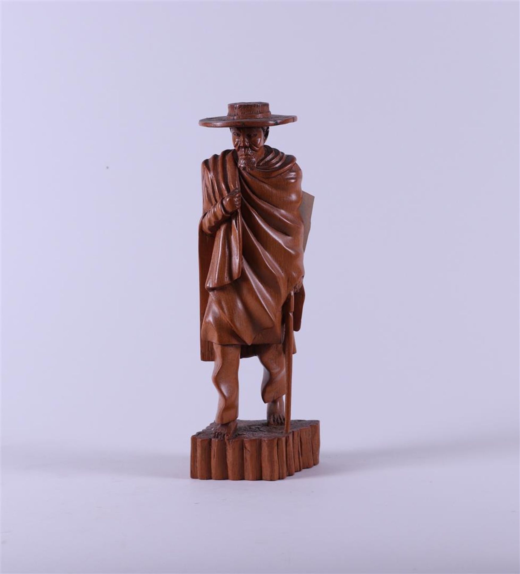 A Madegascar carving depicting a walking man with hat and stick, 20th century. .