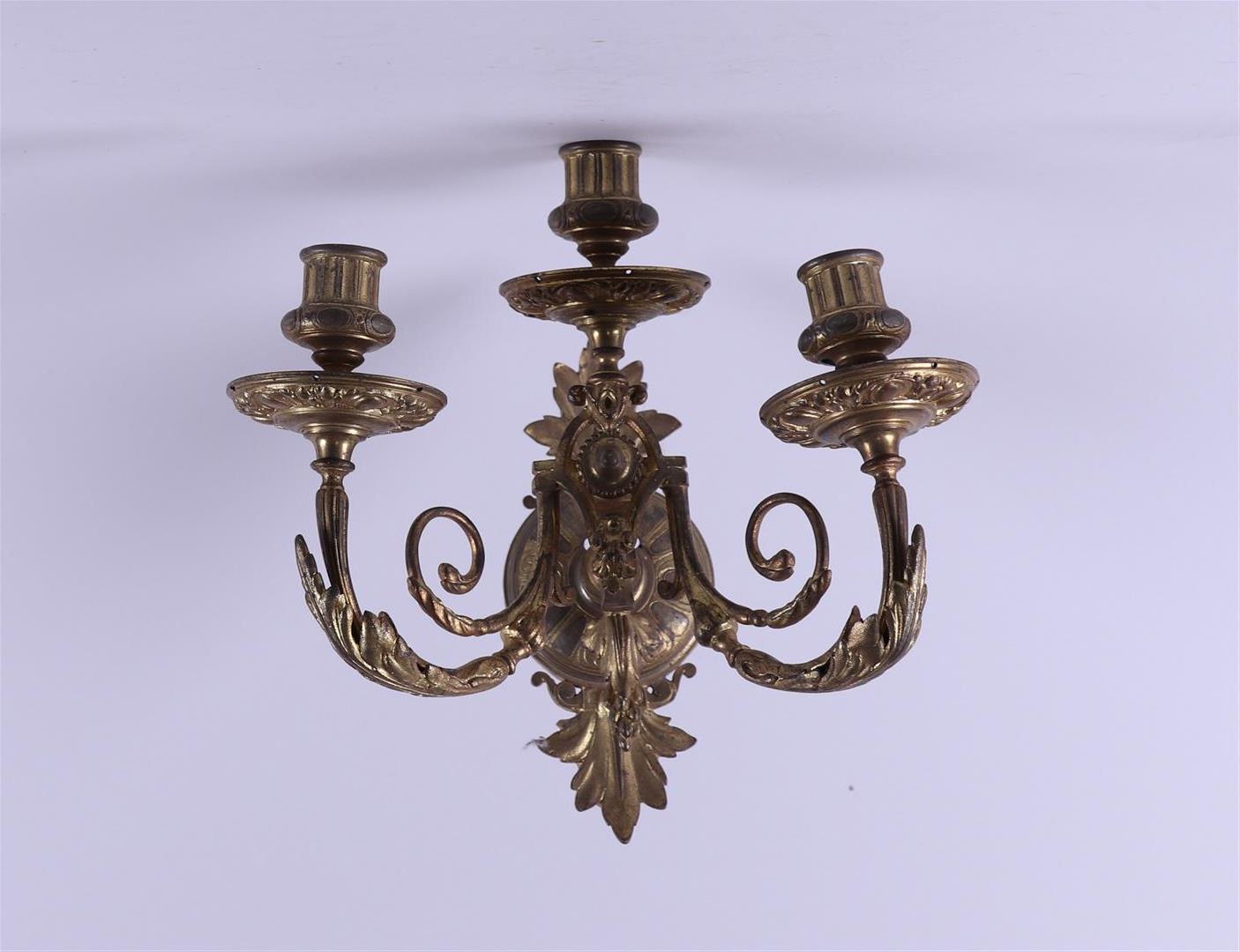 A brass three-armed wall chandelier.Ca. 1900.