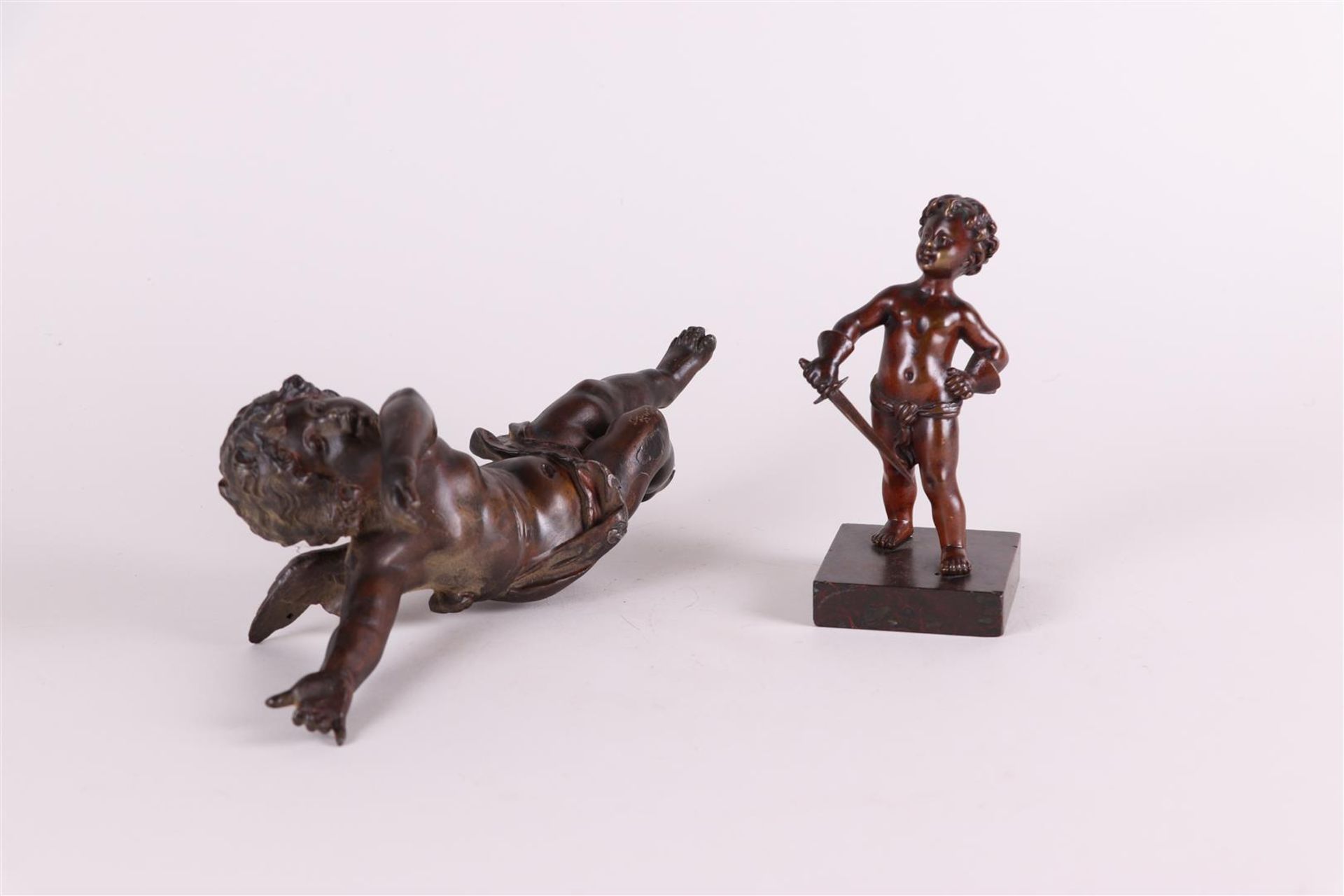 A lot consisting of a zamac puto and two bronze puto on a marble base. Circa 1900.