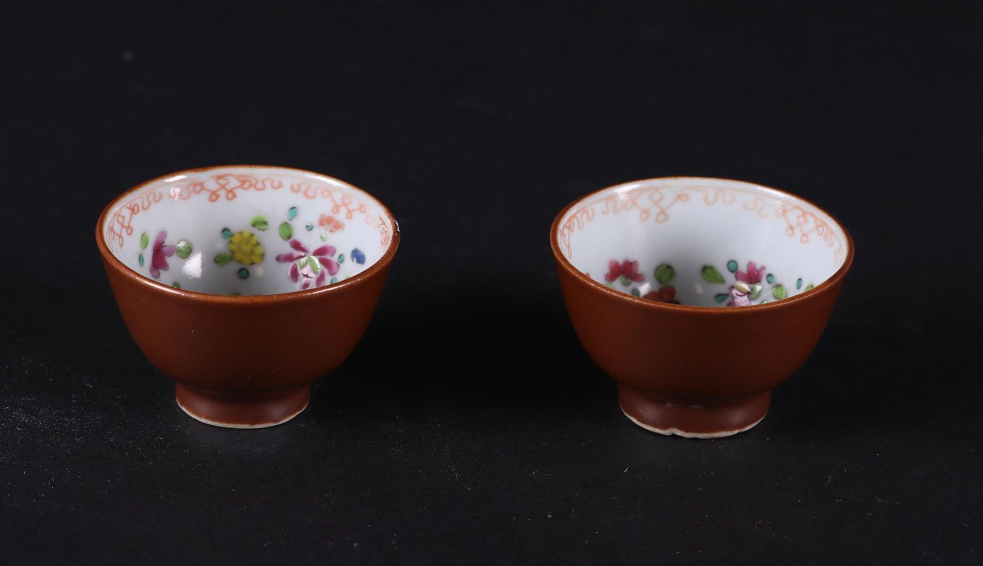 Two porcelain Famille Rose cups with a capuchin exterior and a floral interior. China, Qianlong.